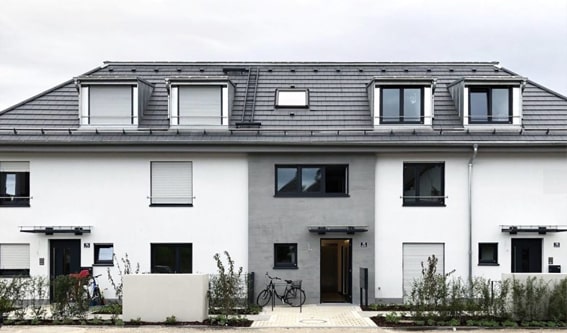 mehrfamilienhaus fassadenarbeiten mit grauem dach und weißen hauswänden